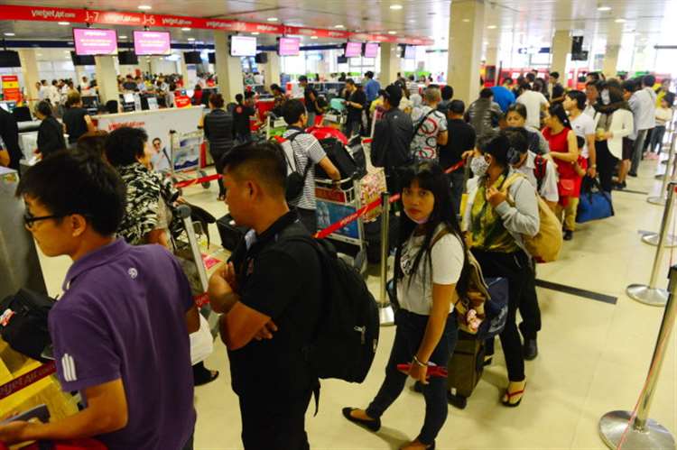 Hành khách xếp hàng lên máy bay tại cửa khởi hành