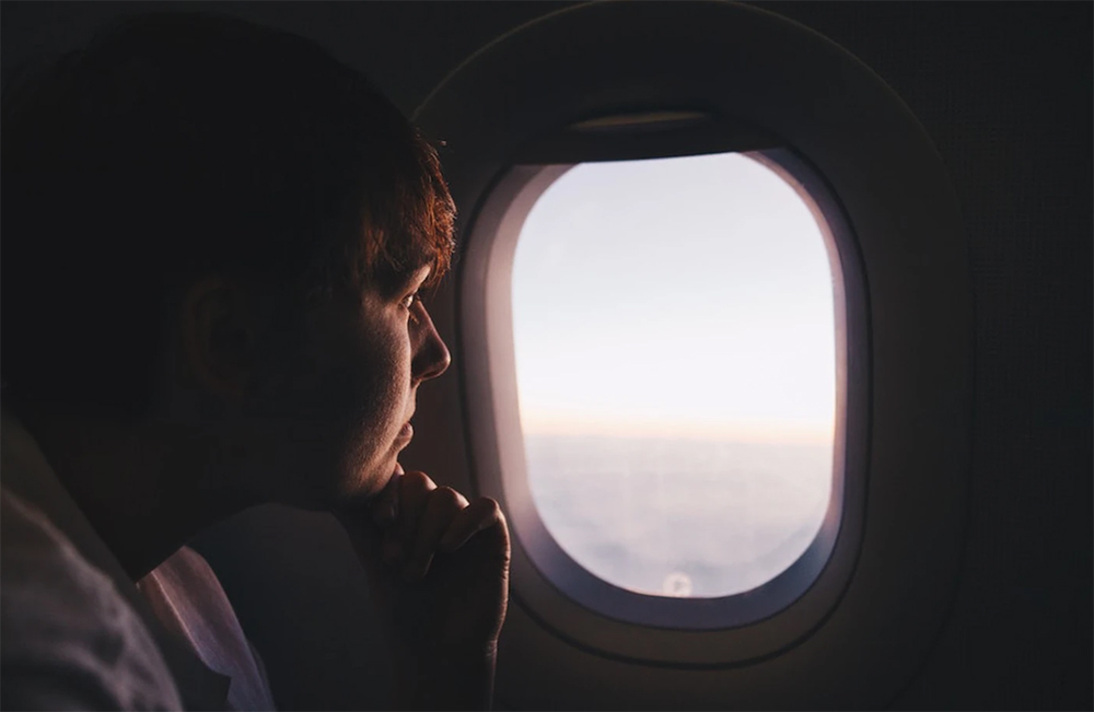 Hành khách ngồi sát cửa sổ đang ngắm cảnh trời