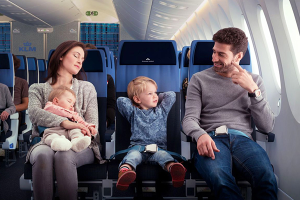 Em bé ngồi trên ghế máy bay bên cạnh bố mẹ